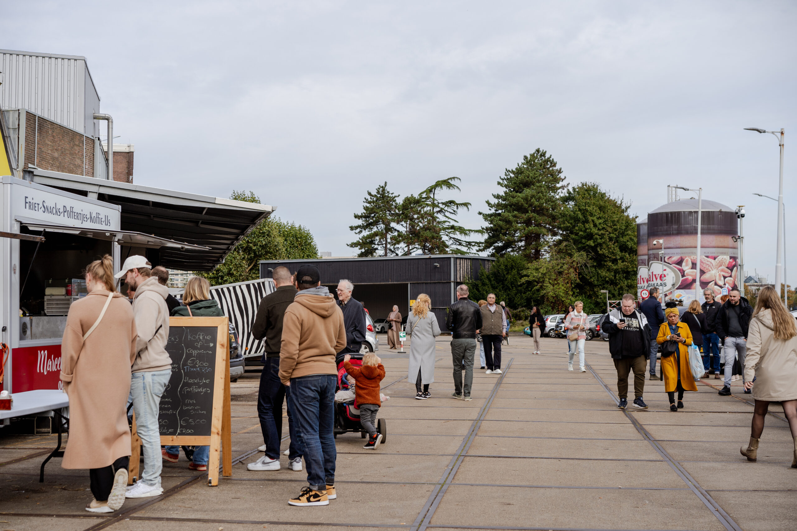 De Kaai Markt met bezoekers die rondkijken en aankopen doen.